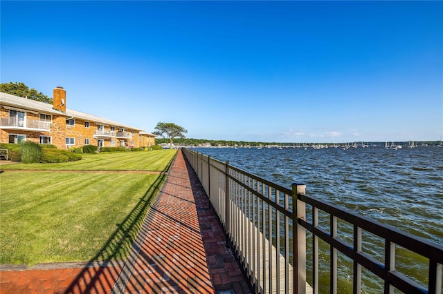 view of community with a water view and a yard