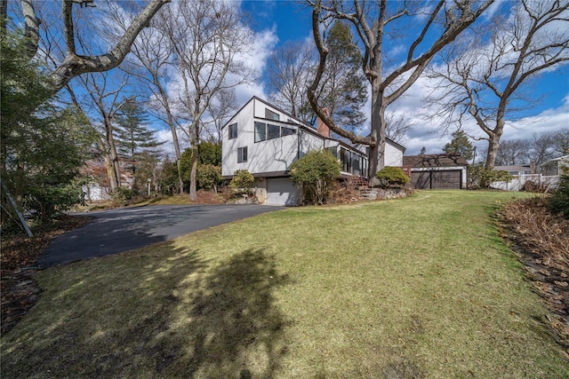 view of yard featuring aphalt driveway and a garage