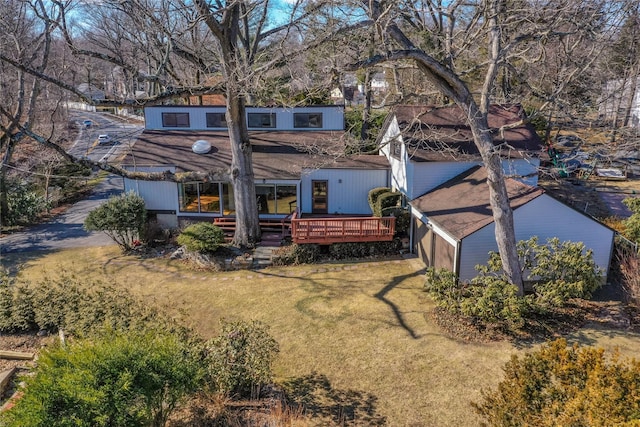 back of property featuring a wooden deck and a yard