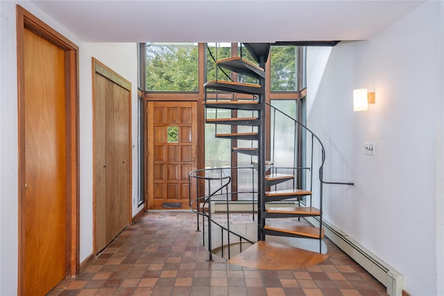 stairway featuring baseboard heating and floor to ceiling windows