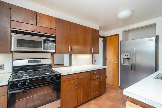 kitchen featuring light countertops, light tile patterned floors, and appliances with stainless steel finishes