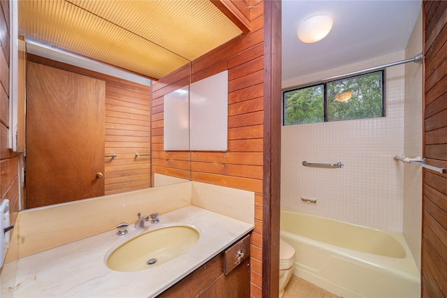 full bath with wood walls, toilet, and vanity