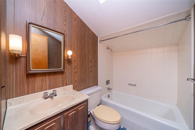 bathroom featuring toilet, wood walls, vanity, and shower / tub combination