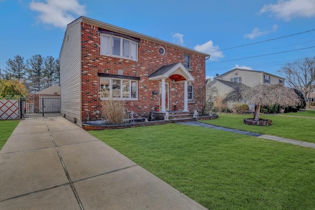 traditional home with a front yard, a gate, fence, and brick siding