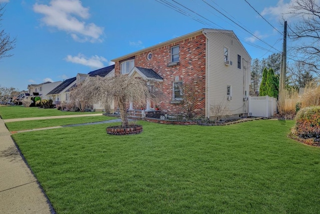 view of front of property featuring brick siding, a front yard, and fence