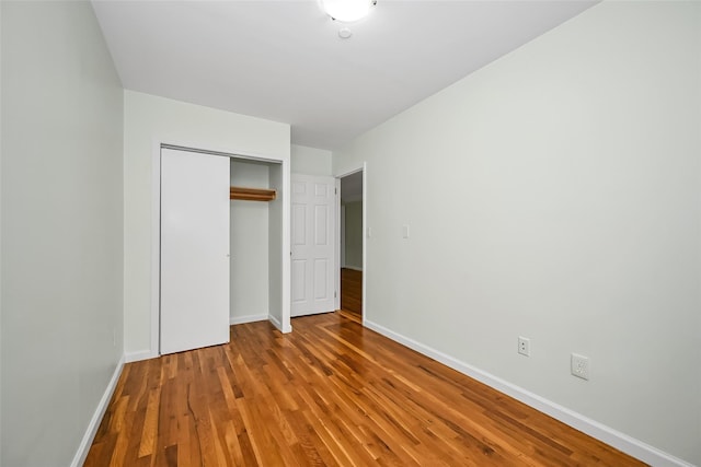 41-38 66th St, Woodside, NY 11377 - unfurnished bedroom with a closet, baseboards, and wood finished floors