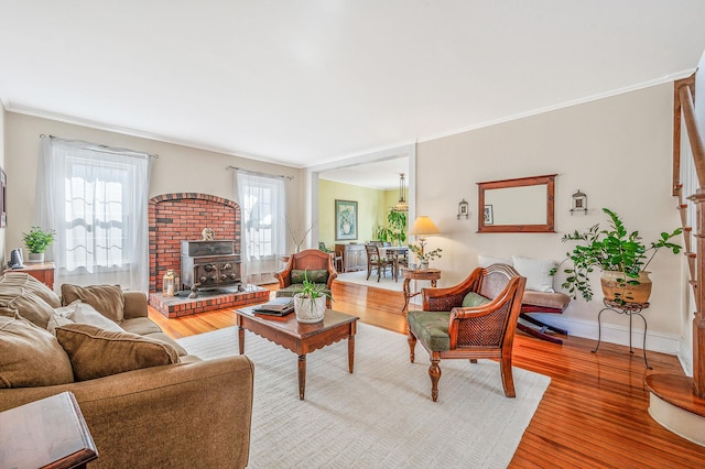 living room with a healthy amount of sunlight, a wood stove, and wood finished floors