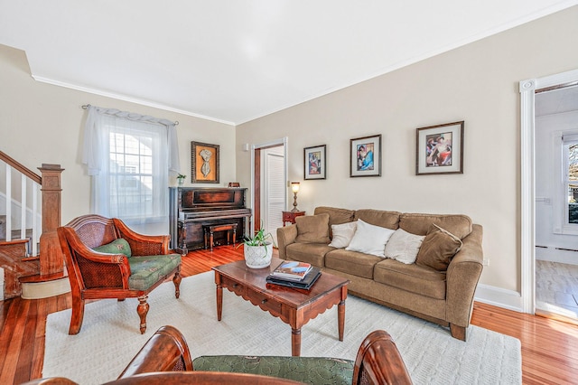 living area with baseboards, wood finished floors, stairs, crown molding, and a fireplace