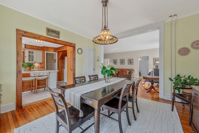 dining room featuring light wood finished floors, baseboards, and a chandelier