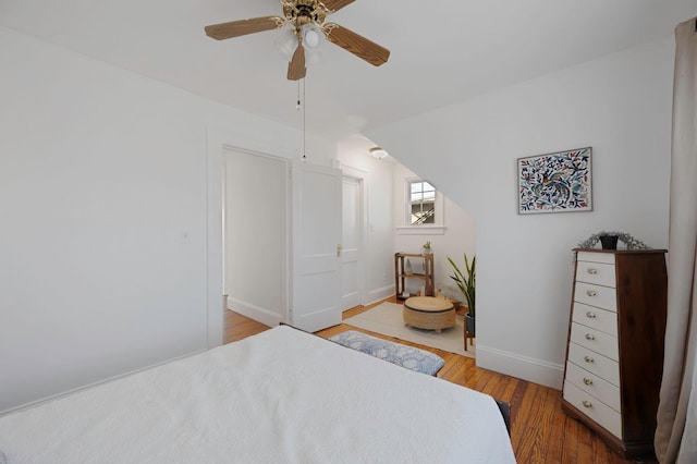 bedroom with ceiling fan, baseboards, and wood finished floors