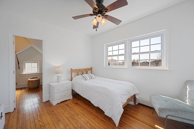 bedroom with ceiling fan, multiple windows, hardwood / wood-style flooring, and baseboards