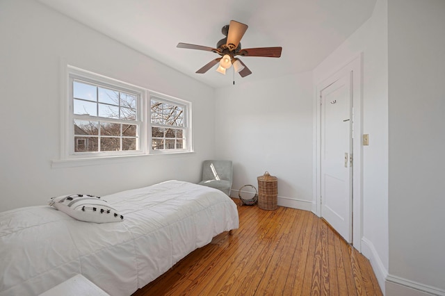 bedroom with wood finished floors, a ceiling fan, and baseboards