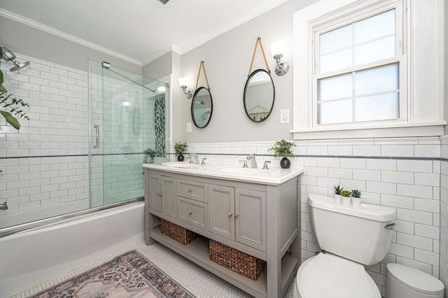 full bath featuring enclosed tub / shower combo, toilet, a sink, ornamental molding, and tile patterned floors