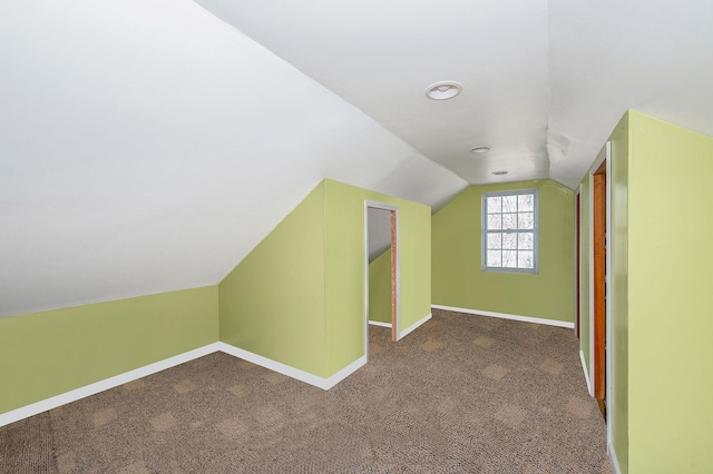 additional living space featuring carpet flooring, vaulted ceiling, and baseboards