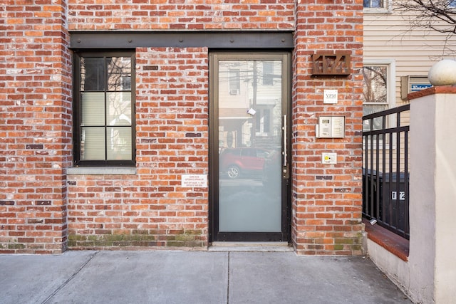 doorway to property featuring brick siding