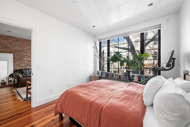 bedroom featuring a fireplace, baseboards, and wood finished floors