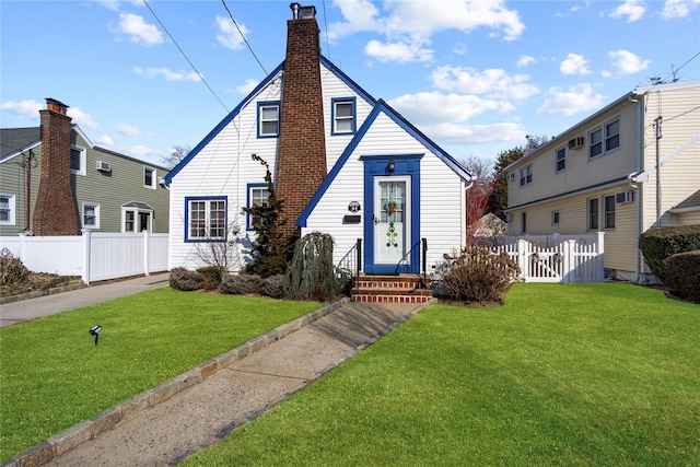 view of front of home featuring entry steps, a chimney, a front yard, and fence