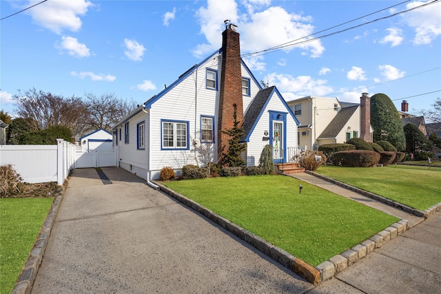 bungalow-style house with a garage, a chimney, aphalt driveway, fence, and a front yard