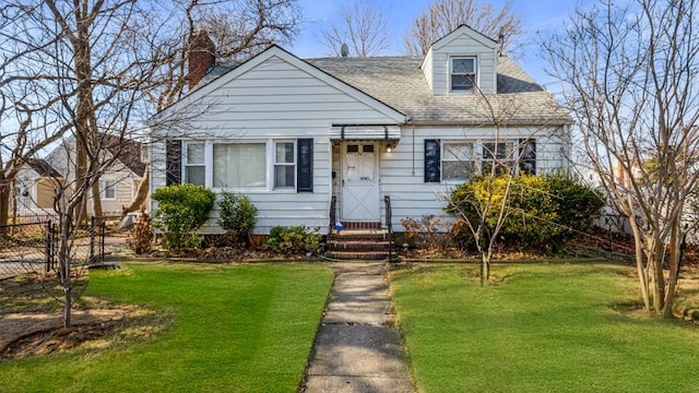 cape cod-style house with roof with shingles, fence, and a front yard