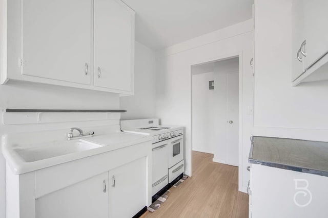 33-65 14th St Unit 5D, Astoria, NY 11106 - kitchen featuring light wood-style flooring, white cabinets, a sink, and double oven range