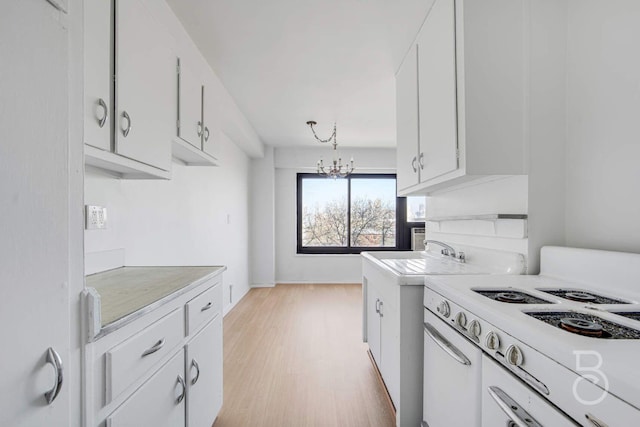 33-65 14th St Unit 5D, Astoria, NY 11106 - kitchen featuring a chandelier, light countertops, white cabinetry, light wood-style floors, and a sink