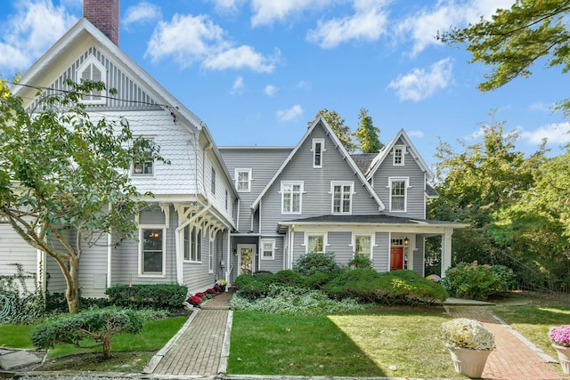 view of front facade featuring a chimney and a front yard