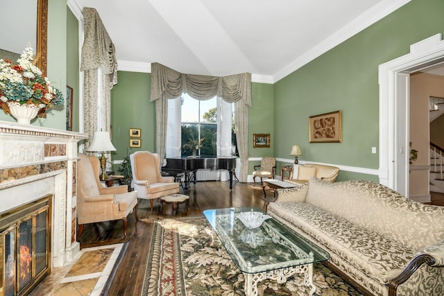 sitting room featuring ornamental molding, wood-type flooring, a fireplace, and stairs