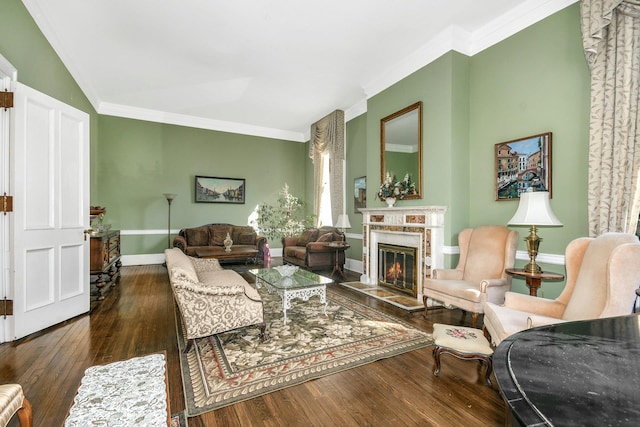 living area featuring hardwood / wood-style flooring, a premium fireplace, baseboards, and crown molding