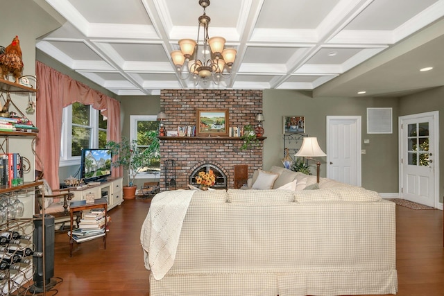 bedroom featuring coffered ceiling, a notable chandelier, a fireplace, and wood finished floors