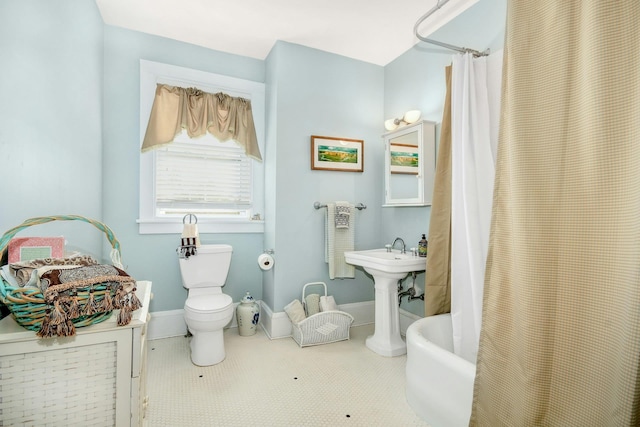 full bathroom with toilet, baseboards, and a shower with shower curtain