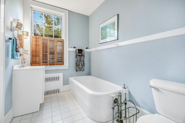 bathroom featuring toilet, radiator heating unit, tile patterned floors, vanity, and a freestanding tub