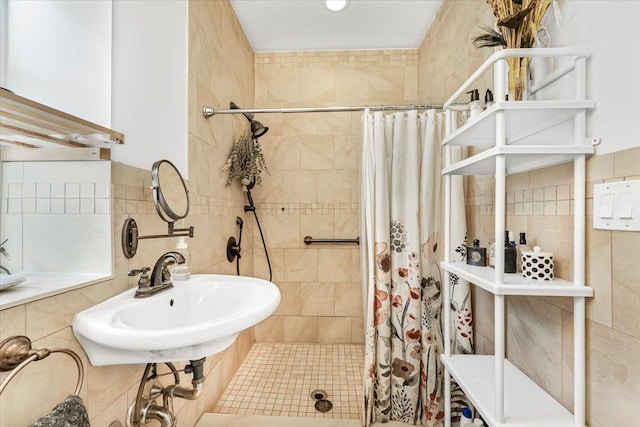 full bath featuring tile walls, a sink, and a shower stall