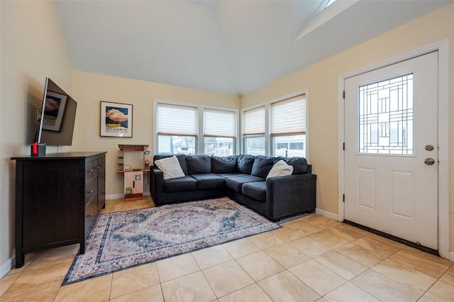 living room with high vaulted ceiling, baseboards, and light tile patterned flooring