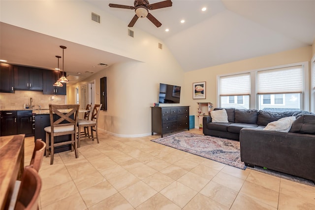 living room featuring high vaulted ceiling, visible vents, and baseboards