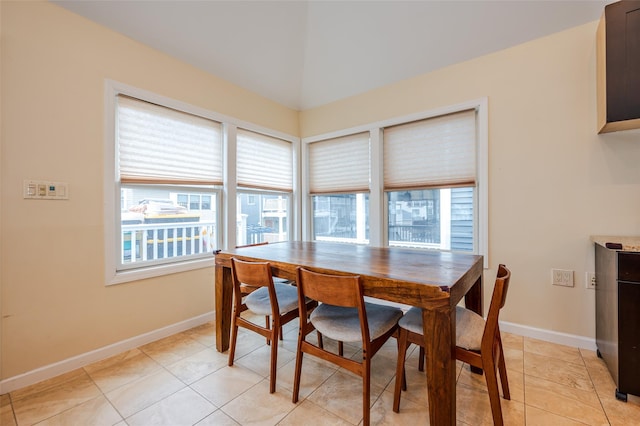 dining space featuring baseboards and light tile patterned flooring