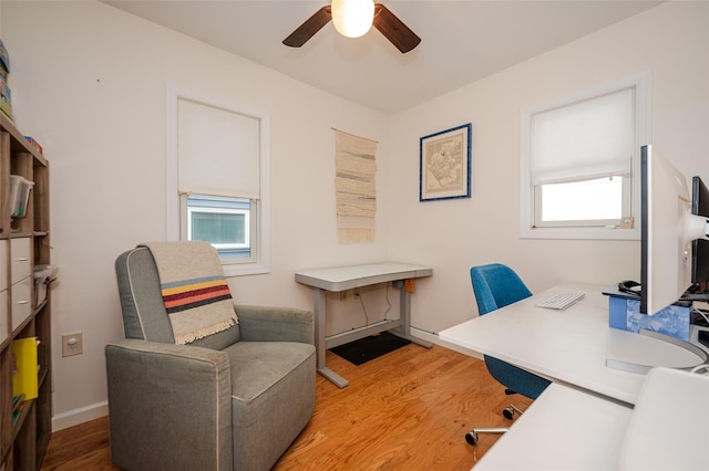 office area featuring a ceiling fan, baseboards, and light wood finished floors