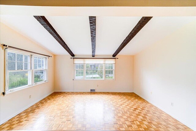 spare room featuring baseboards, visible vents, and beam ceiling