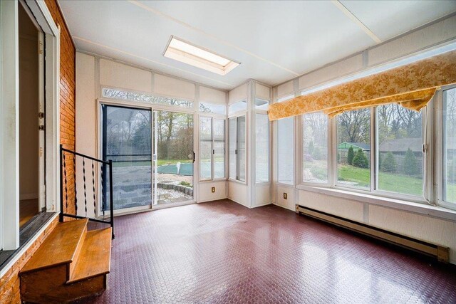 unfurnished sunroom with a baseboard heating unit and lofted ceiling with skylight
