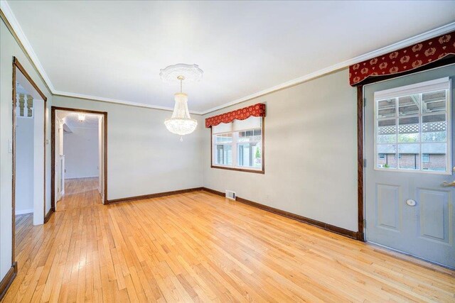 unfurnished dining area with visible vents, crown molding, baseboards, a notable chandelier, and light wood-style floors