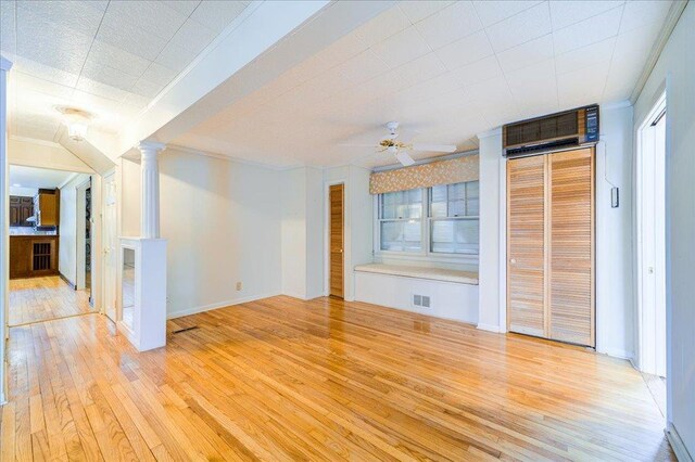 empty room with visible vents, ornamental molding, ceiling fan, ornate columns, and light wood-style flooring