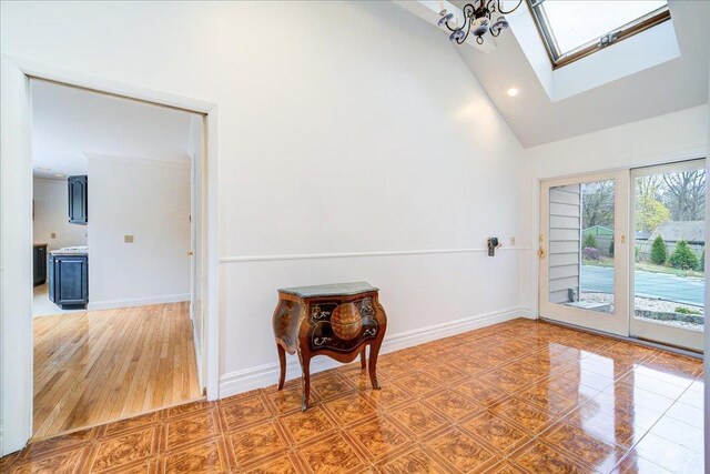 interior space featuring tile patterned flooring, high vaulted ceiling, recessed lighting, baseboards, and a skylight