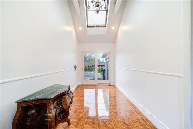 doorway to outside featuring a skylight, tile patterned floors, baseboards, high vaulted ceiling, and recessed lighting