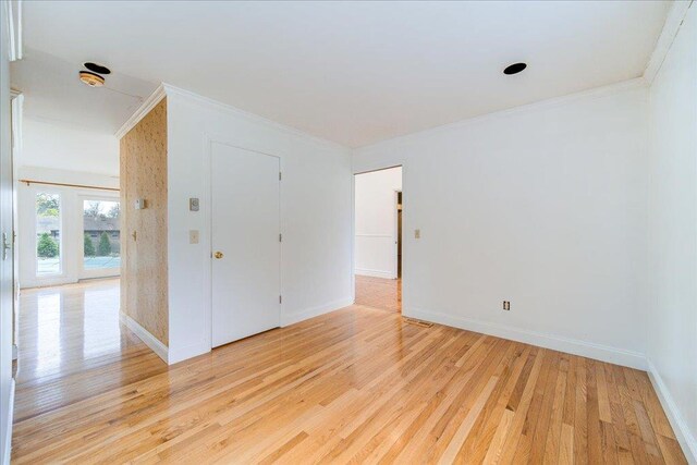 unfurnished room featuring baseboards, ornamental molding, and light wood finished floors