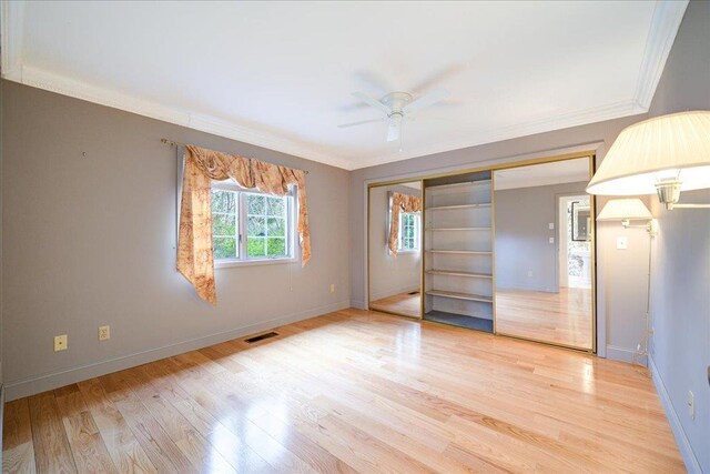 unfurnished bedroom with crown molding, baseboards, and light wood-type flooring