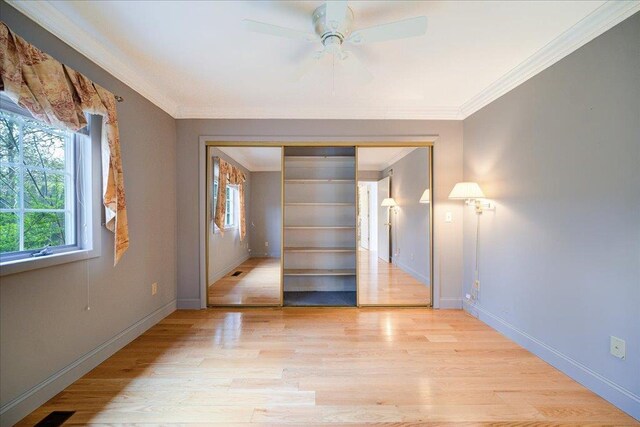 empty room with light wood-style floors, baseboards, and crown molding
