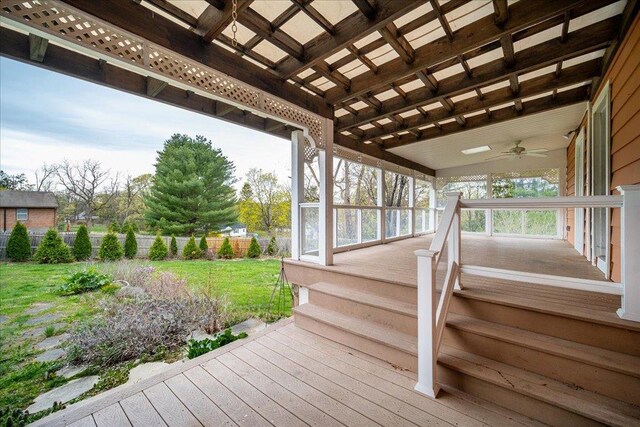 wooden deck featuring a lawn, ceiling fan, and fence