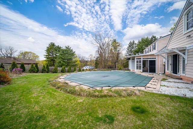view of pool featuring a lawn, fence, and a fenced in pool