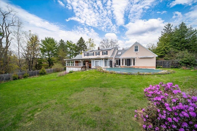 rear view of property with a lawn, a chimney, and a fenced backyard