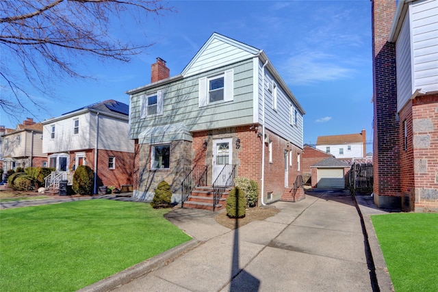 view of front facade with entry steps, brick siding, an outdoor structure, a front lawn, and a chimney