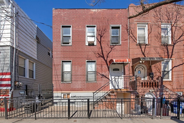 view of property with a fenced front yard and brick siding